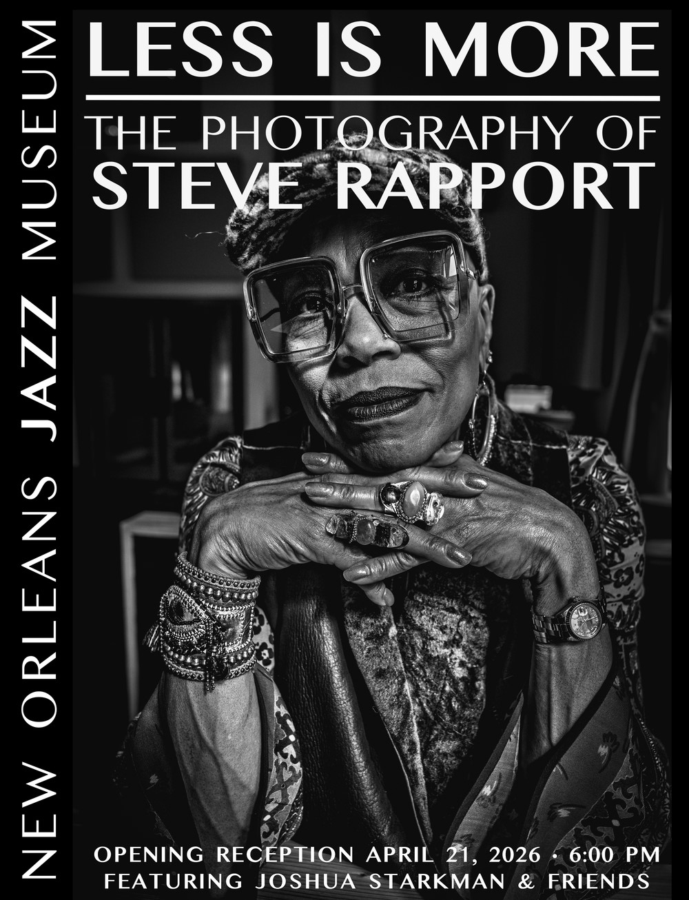 Black-and-white exhibition poster featuring a close-up portrait of a woman wearing artsy square glasses, layered bracelets, rings, and a patterned outfit, resting her chin on her hands. Large text reads “Less Is More: The Photography of Steve Rapport.” Vertical text along the side reads “New Orleans Jazz Museum.” The poster also includes details for an opening reception on April 21, 2026, at 6:00 p.m., featuring Joshua Starkman and friends.