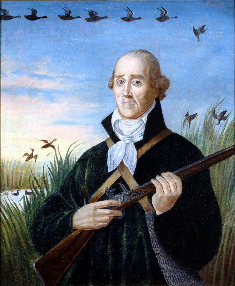 Portrait of a solemn man standing in a marsh, holding a long flintlock rifle across his body. He wears a dark coat, white cravat, and crossed leather straps. Ducks fly overhead and rise from the reeds against a blue sky.