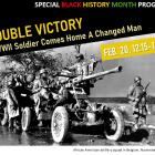 Black-and-white historical photograph of an African American U.S. Army artillery squad operating a large field gun beside a military vehicle on a muddy road in Belgium during World War II, November 1944.