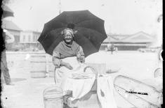 Praline Seller in Sun. George François Mugnier, c. 1885. Collodion on glass plate, 8 x 10 inches. Louisiana State Museum 09813.0022.