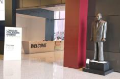 A bronze statue of Dr. Martin Luther King Jr. stands near the entrance to the Louisiana Civil Rights Museum. Behind it, the museum’s modern lobby features a large “WELCOME” desk and signage displaying the museum’s name and logo in bold black and red lettering. The space has clean white walls, polished floors, and contemporary architectural details.