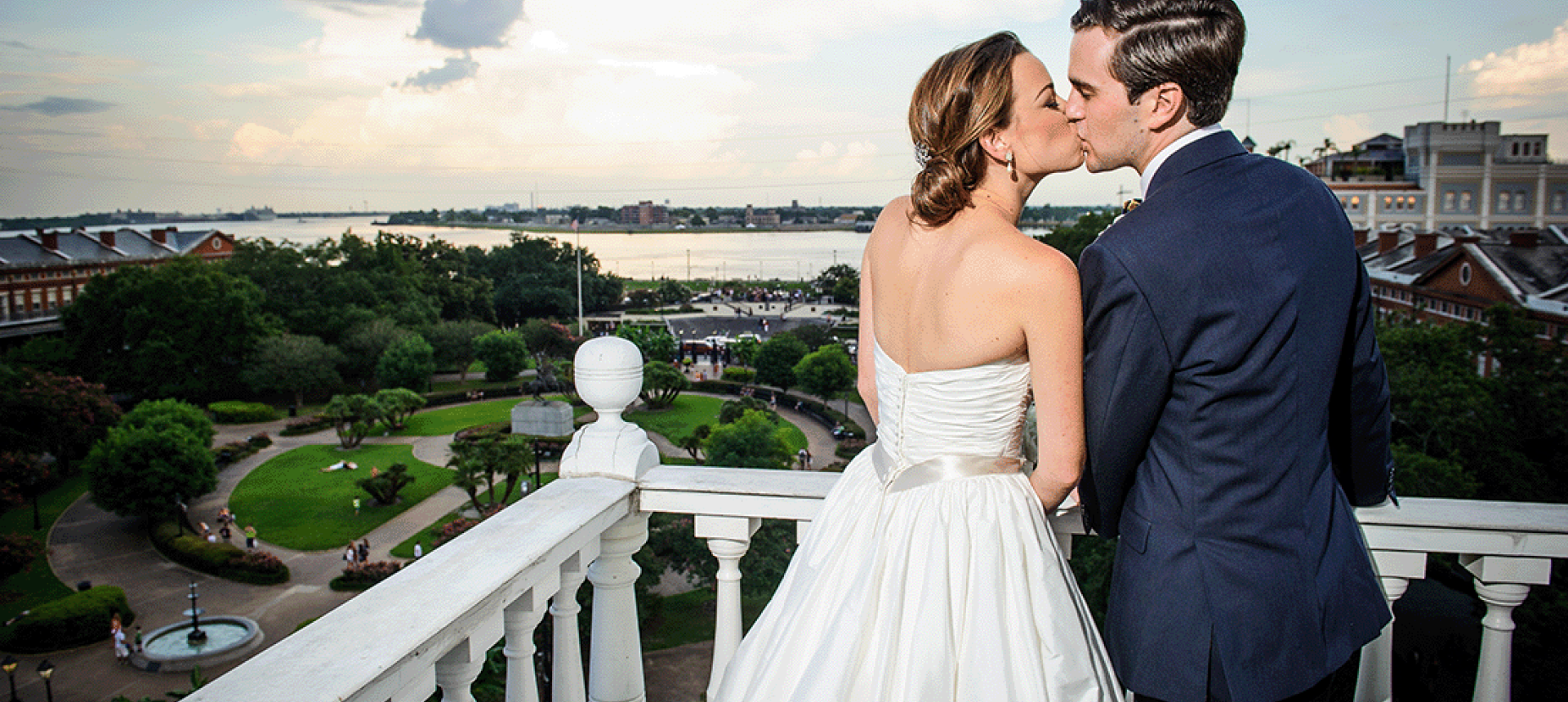 A happy, newly married couple share a kiss on top of the Cabildo overlooking Jackson Square
