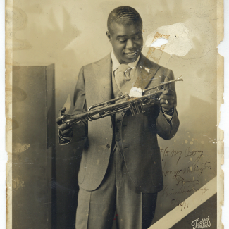 Louis Armstrong looking down at trumpet he is holding; Photo is signed "To my Boy Lonzo Washington From Louis Armstrong 8/23/31," Courtesy of the New Orleans Jazz Club, Louisiana State Museums 1978.118(B).00142.1